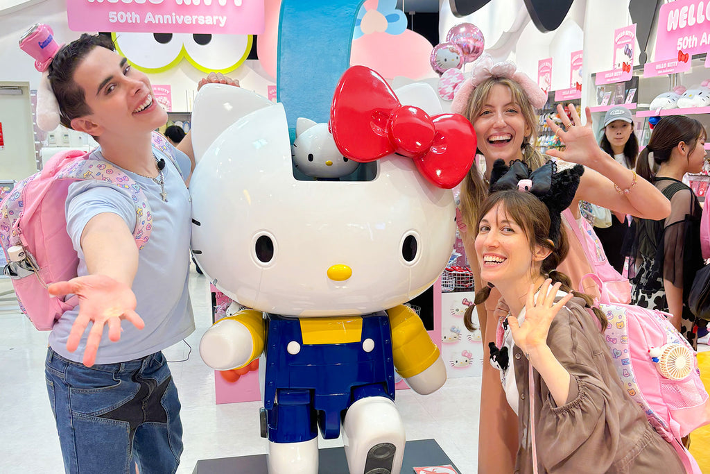 People posing with a large Hello Kitty figure at a Hello Kitty event.